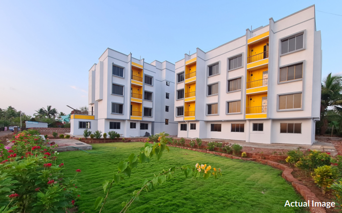 Photograph of the completed Omkar Complex Phase 1 building with a landscaped lawn